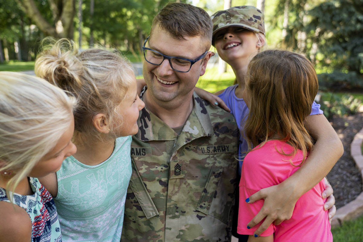 Veteran father embracing his family.